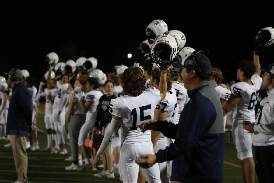 Junior Daniel Blaine joins in raising his helmet with his teammates.