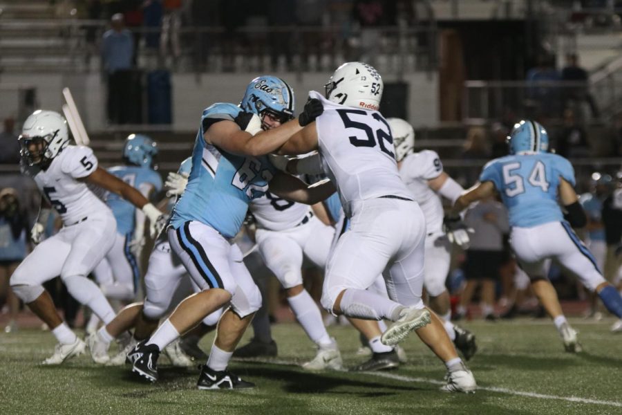 Trying to block the opponent, senior Grant Rutkowski grabs a hold of the opposing  team.