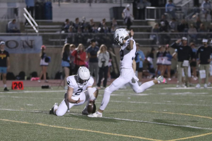 After scoring a touchdown, junior Kenten Laughman kicks a field goal for an extra point.