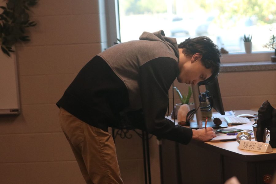 After winning the round, senior quiz bowl captain Jackson Wilhoit signs his name to lock in their victory.