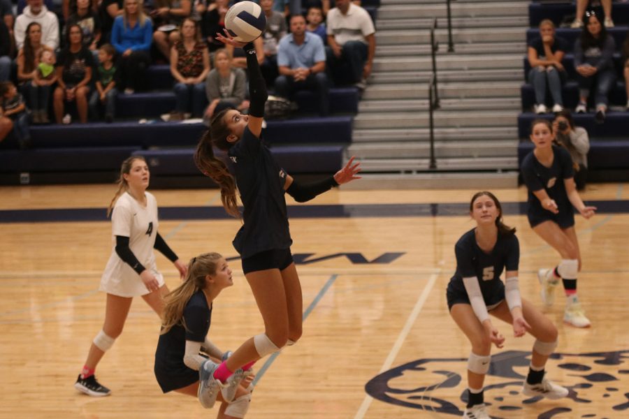 Focusing on the ball, freshman Ella Florez taps the ball over the net.