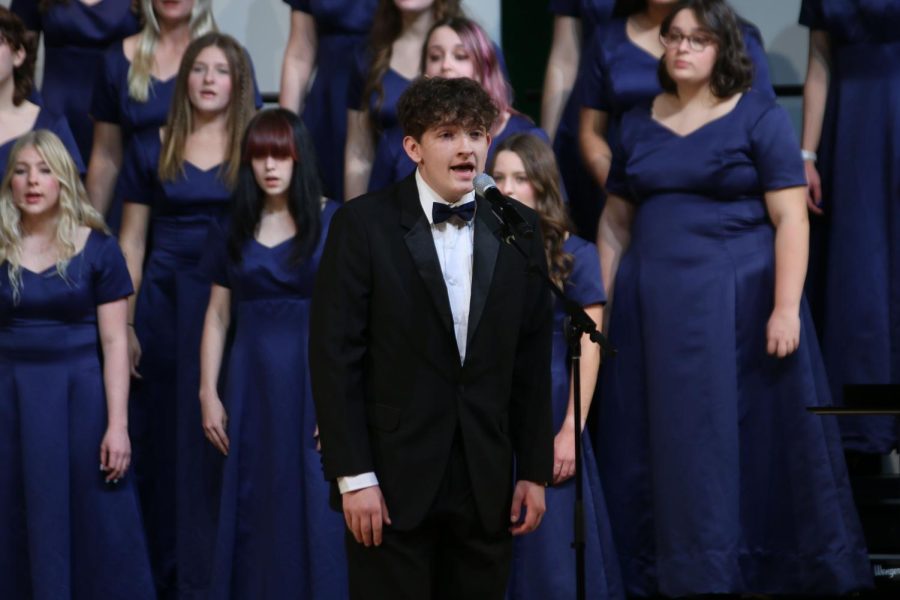 Standing in front of the choir, sophomore Blake Gray sings a solo. 