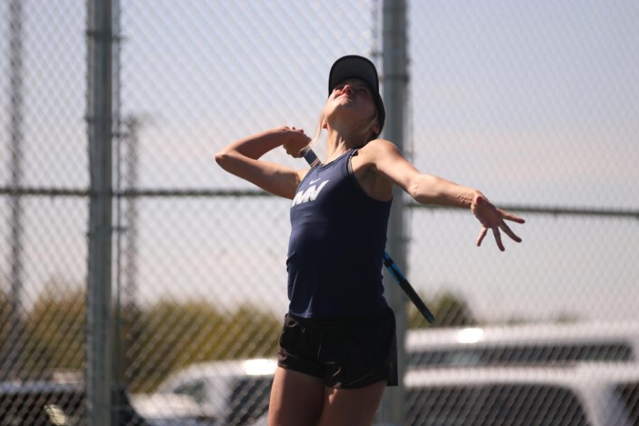 Determined, senior Skylar Szoke rapidly swings her arm to serve the ball. 