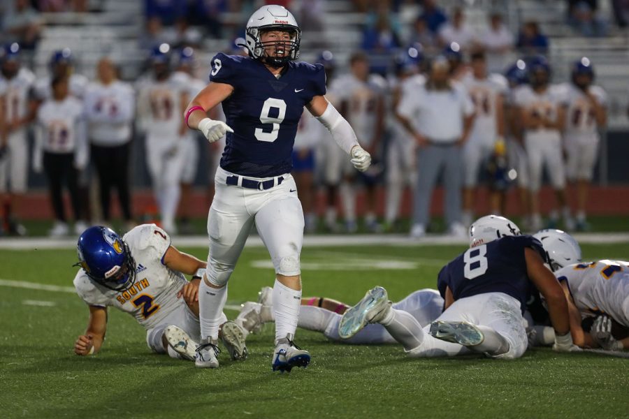 After an exciting play, senior Noah Coy walks off the field triumphantly leaving the people he tackled behind. 