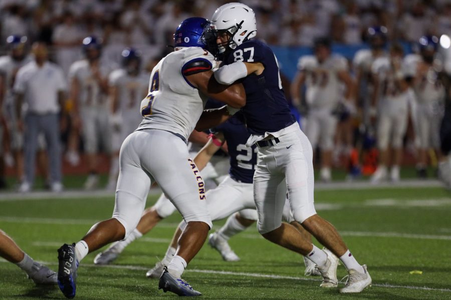 Trying to keep the player  away from the quarterback, senior Will Smoots holds his opponent back.