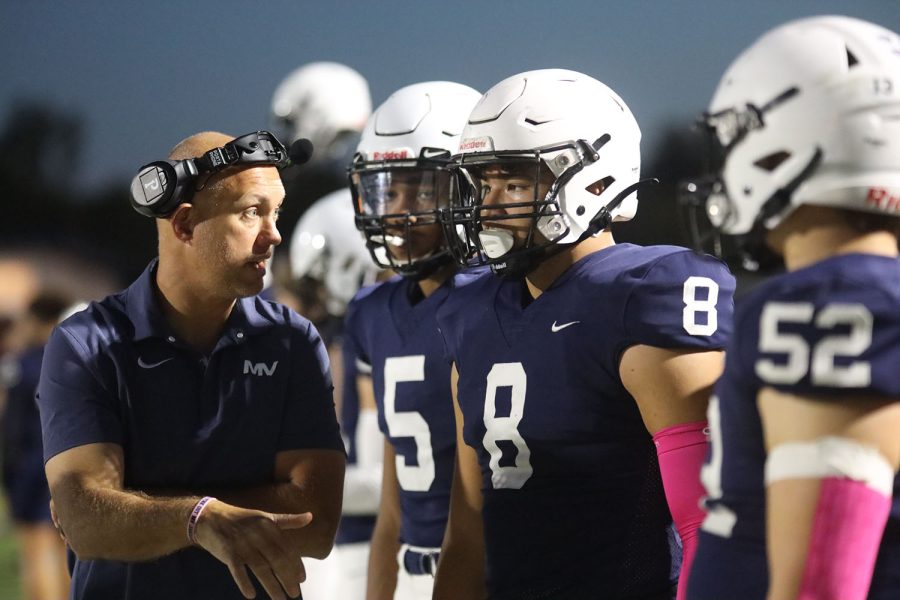 Getting advice on his previous play, junior Truman Griffith listens to his coach.