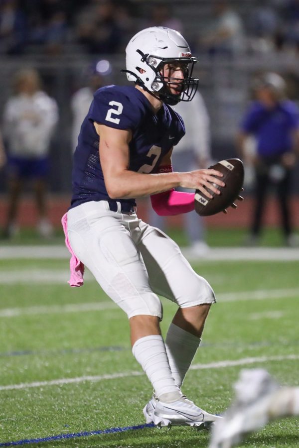 After receiving the snap, senior Hayden Jay looks down the field for an open teammate. 