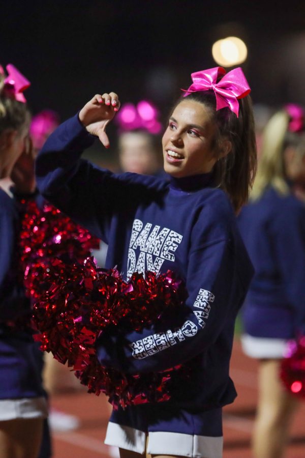Looking into the student section, senior Sidney Claeys makes a heart with her hands. 