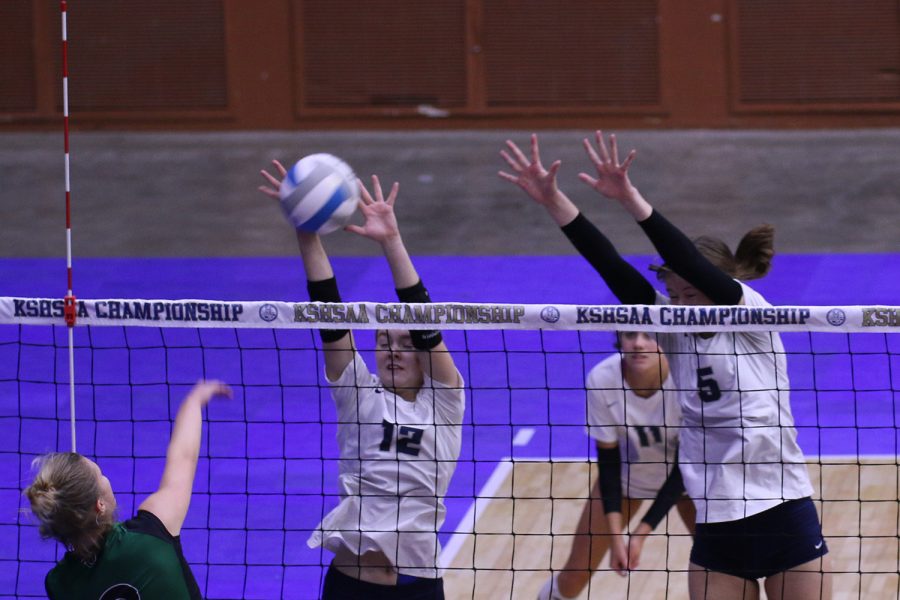 Stuffing their Free State opponent, junior Addison Bailey and sophomore Saida Jacobs extend their arms over the net. The team beat Free State 2-0 in the second match of the state tournament.