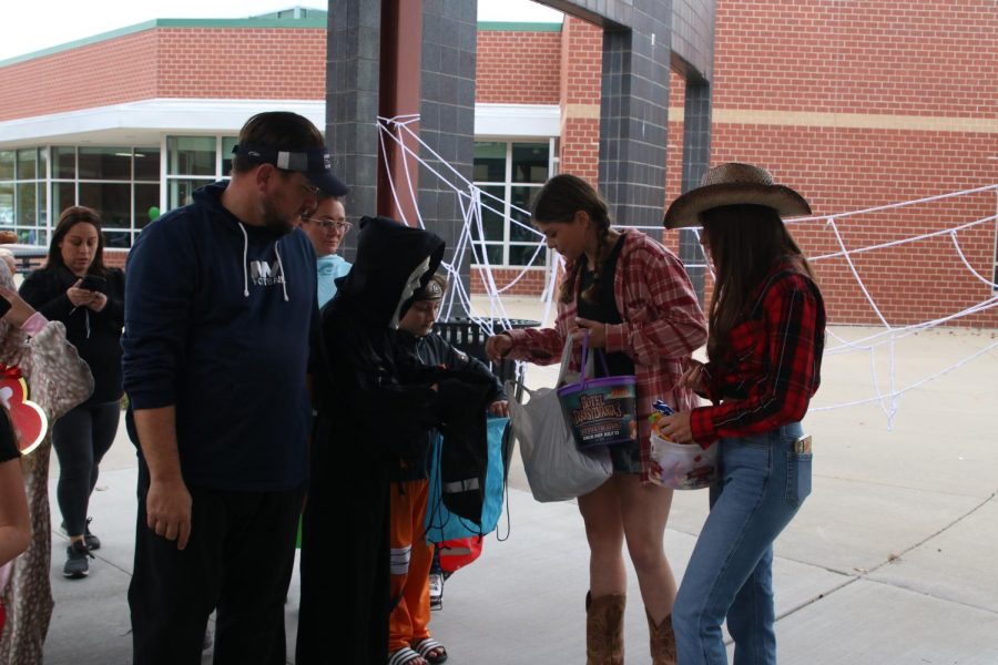 Among other StuCo and JLC members, junior Kate Pfiester gives out candy to waiting kids.