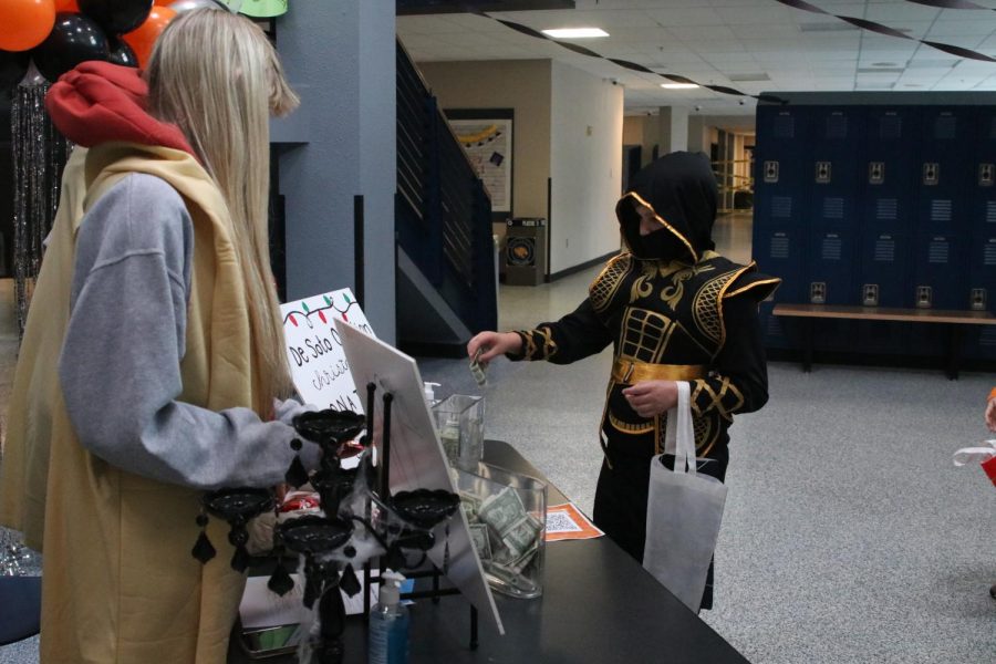 Toward the front of the school when participants enter, an elementary schooler donates money to the DeSoto Food Pantry fundraiser.