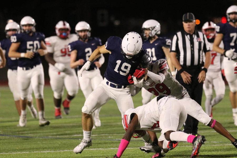 Senior Hayes Miller holds onto the ball while having two defenders on him. 