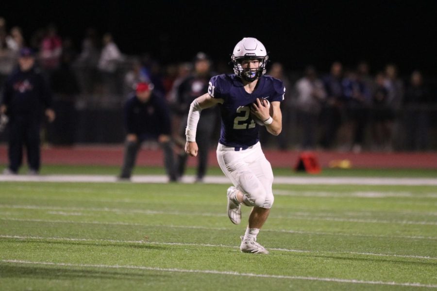 With no one around him, junior Tristan Baker runs down the field with the ball. 