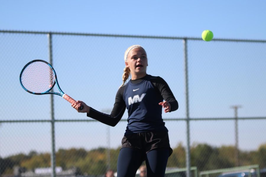 Swinging her racket, senior Bri Coup returns the ball to the other side of the net.