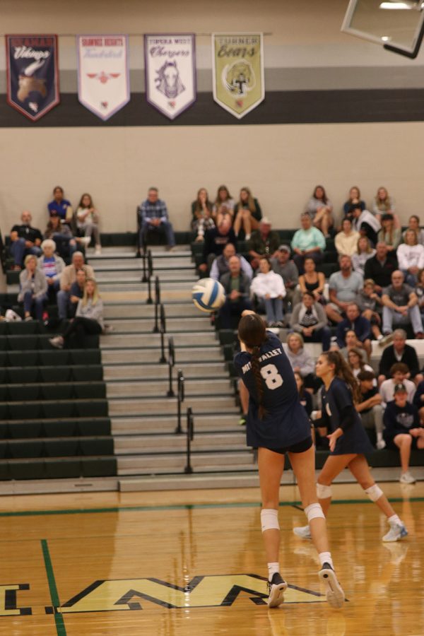 Leaning forward, sophomore Ashlyn Blazer passes the ball over the net. 
