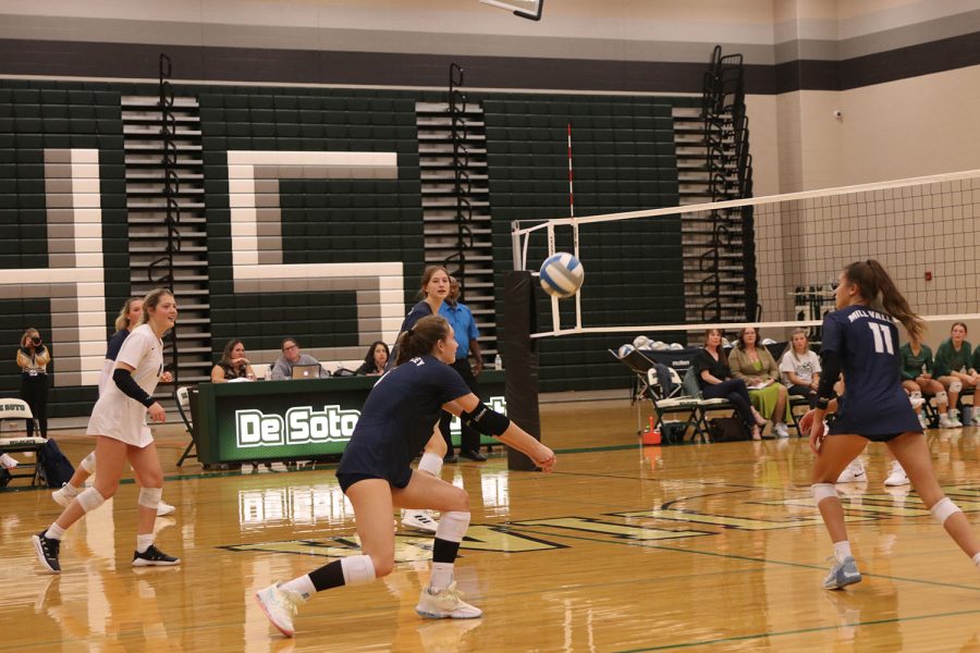 Knees bent, junior Kaitlyn Burke passes the ball to a teammate. 
