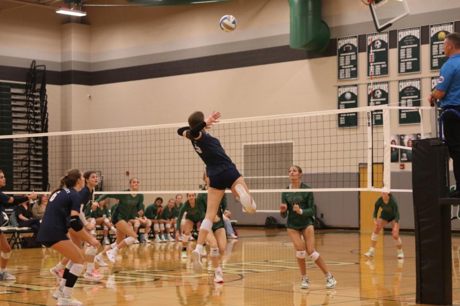 Winding up above the net, sophomore Saida Jacobs prepares to slam the ball into the opponents half. 
