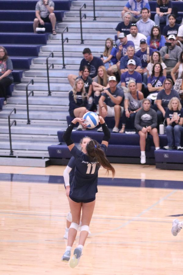 Jumping in the air, freshman Ella Florez sets the ball to one of her teammates. 