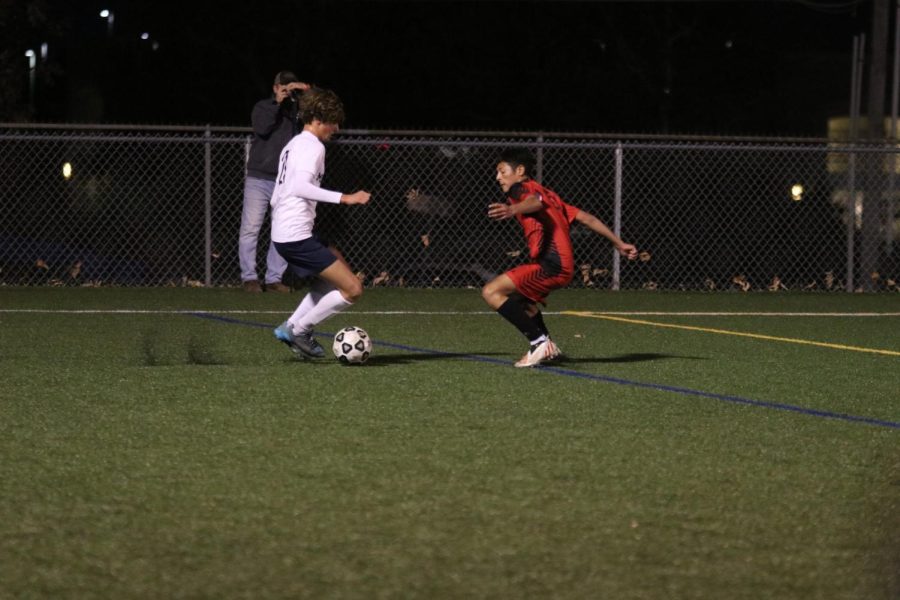 In a one-on-one matchup, sophomore Nic Schrag attempts to fake-out his opponent.