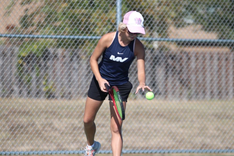 Bouncing the ball, freshman Heidi Baillos prepares to serve.