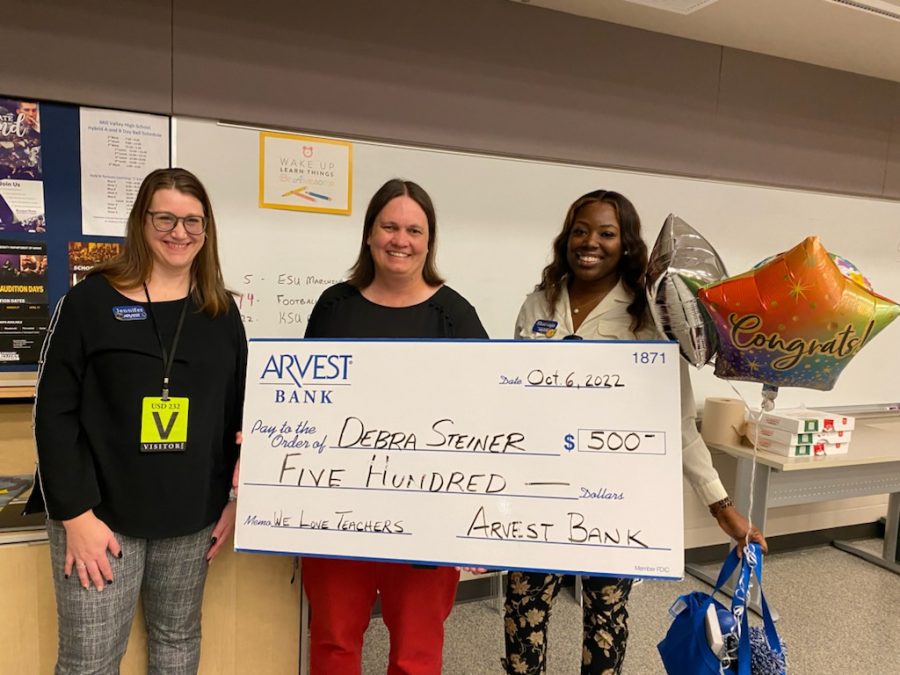 Standing together, band teacher Deb Steiner and representatives from Arvest Bank hold the $500 check that was presented to Steiner