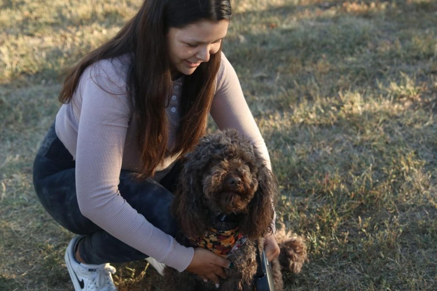 Sophomore Celeste White bends down to pet her dog Maizey.
