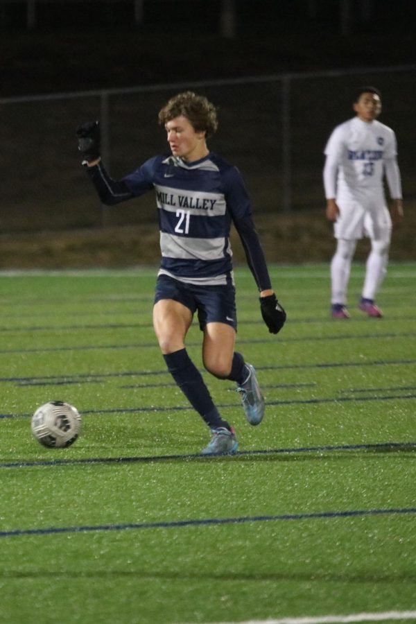 Dribbling down the middle of the field, sophomore Nic Schrag focuses on the ball in front of him.