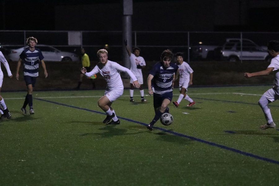 Senior Toby Kornis dribbles the ball towards the goal past his opponents. 