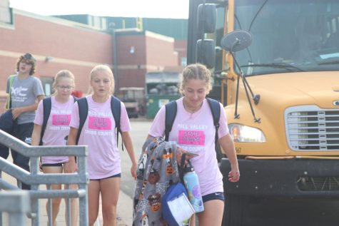 Exiting the bus, junior Sarah Anderson followed by freshman Jenna Lloyd and sophomore Laura Hickman walk inside the school. The girls cross country team finished in sixth place at the 6A State Championship meet Saturday, Oct. 29 with sophomore Charlotte Caldwell placing among the top 20 finishers.