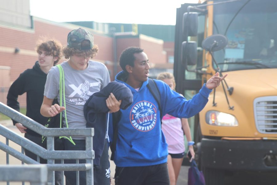 Junior AJ Vega points in the distance whilst standing next to freshman Jordan Schierbaum as they get off the bus.