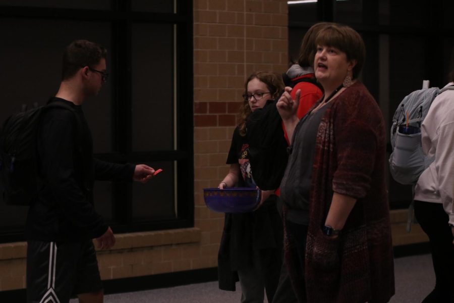 Broadcast journalism teacher Laurie Folsom monitors ticket collection as students file into the PAC.