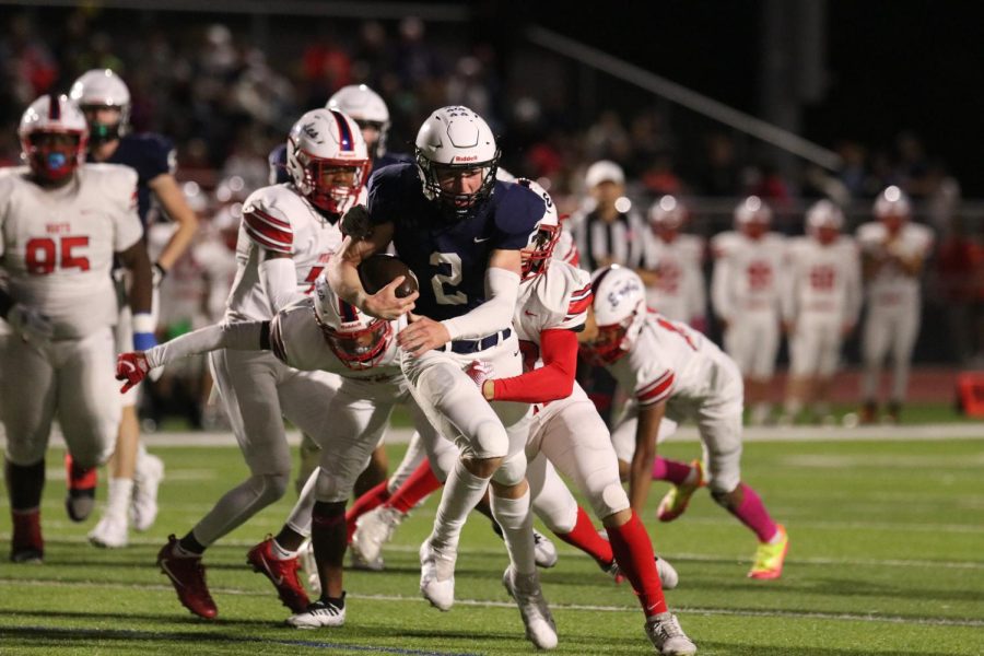 Quarterback senior Hayden Jay runs through a pack of Olathe North defensive lineman.