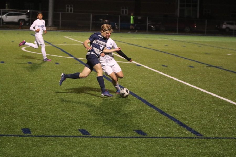 Going head to head with an opposing  player, senior Jack Ward fights to gain possession of the ball.