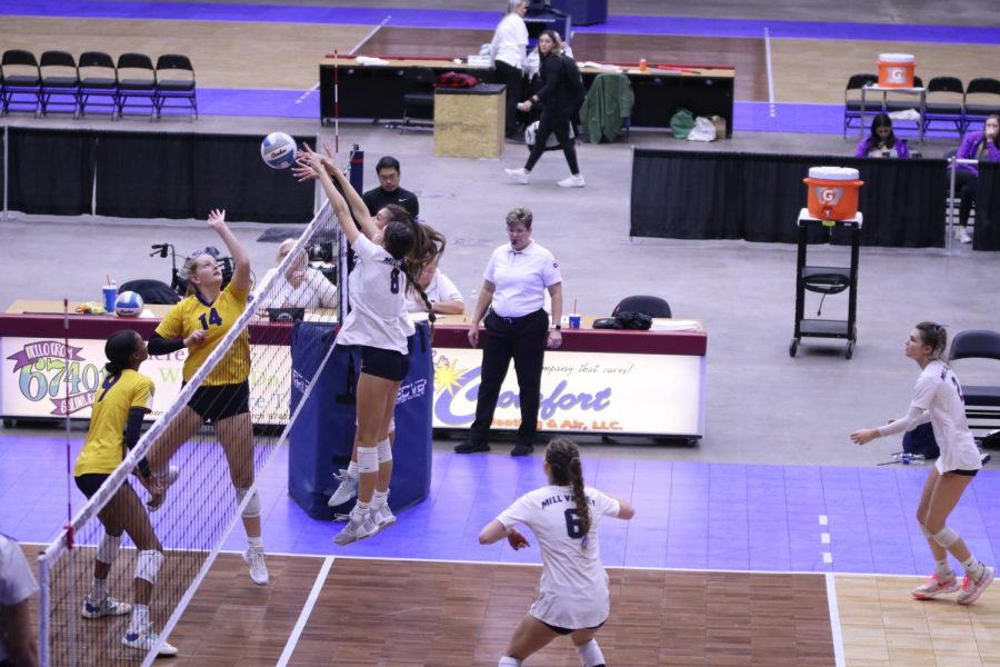 Getting their hands on the ball, sophomore Ashlyn Blazer and freshman Ella Florez block the ball from going over the net.