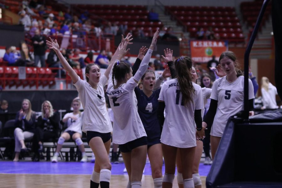 With their hands raised, the team celebrates after scoring a point.