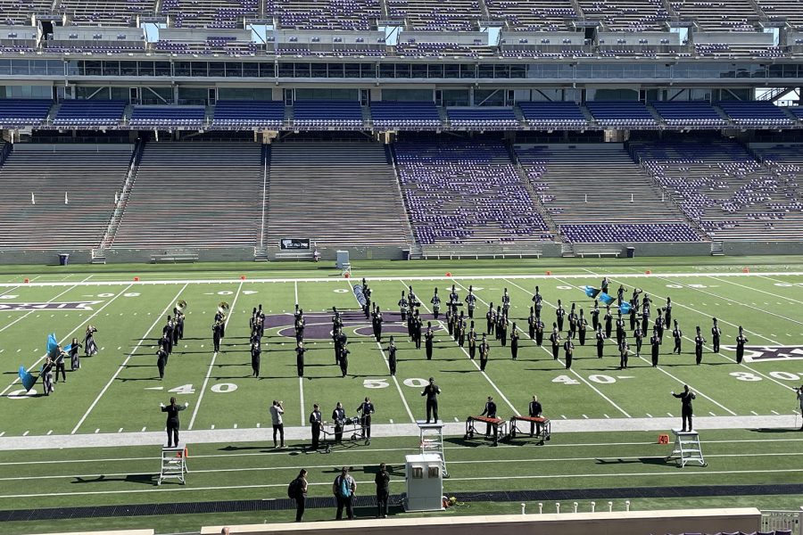 Standing in formation for movement one, the members of the band play the song “Shockwave” while they compete. 