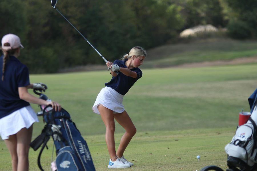 While focusing on the ball, freshman Sydney Epperson raises her club for the tee off. 