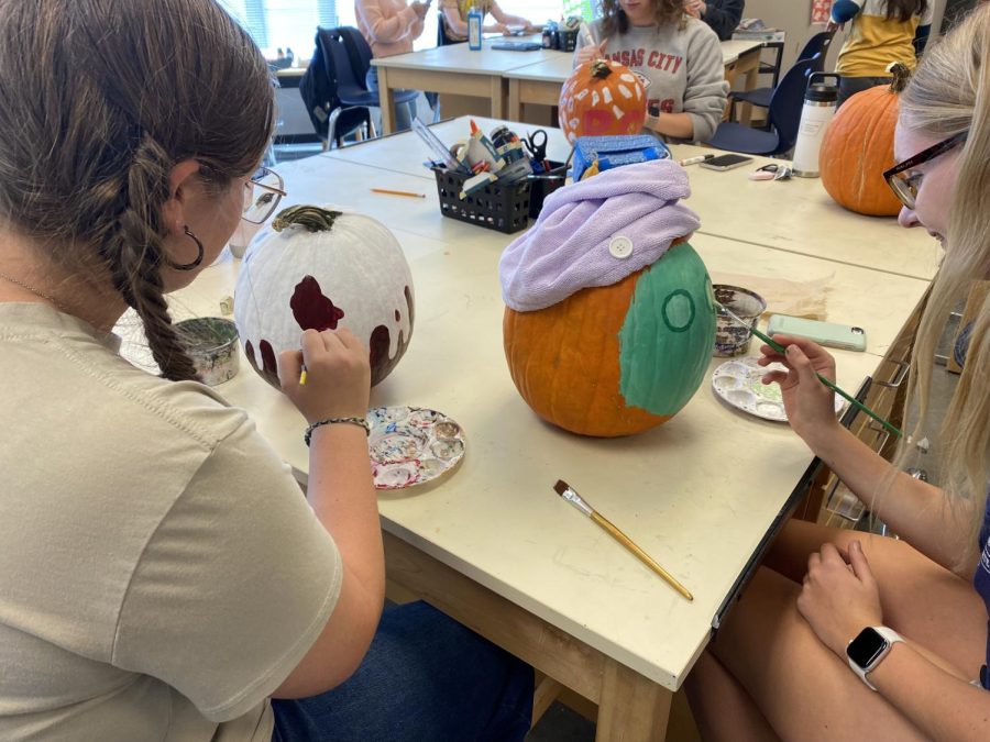 Sophomore Marissa Akehurst works on finishing her spa-day themed pumpkin alongside freshman Liberty Bouskill who paints her pumpkin in red and white.