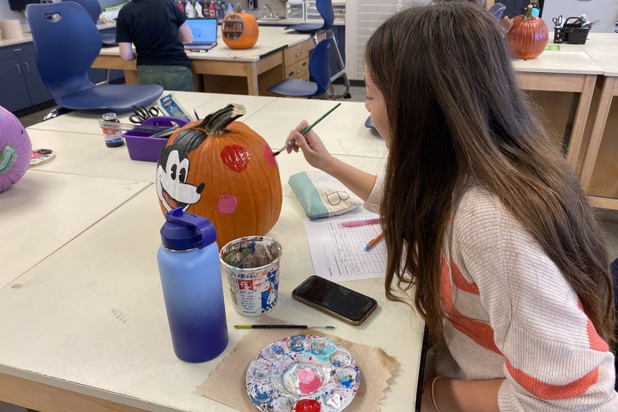 Volunteering her time at the NAHS Pumpkin Palooza event, sophomore Brooklyn Markovich works on her pumpkins design Thursday Oct. 13.