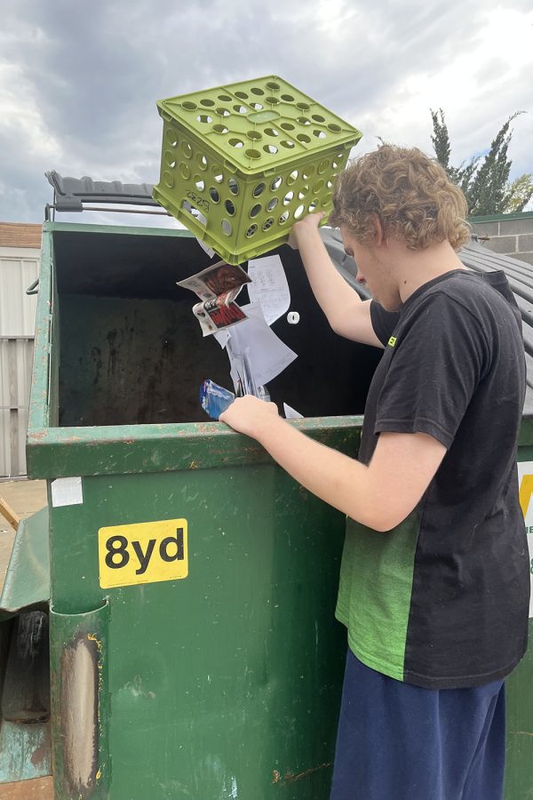 Standing by the recycling bin, senior Mikey Jobe empties out papers on Wednesday, Oct. 5. 