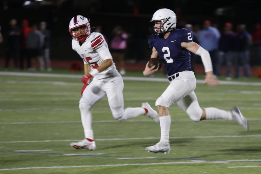 Evading a defender, quarterback senior Hayden Jay runs down the field.
