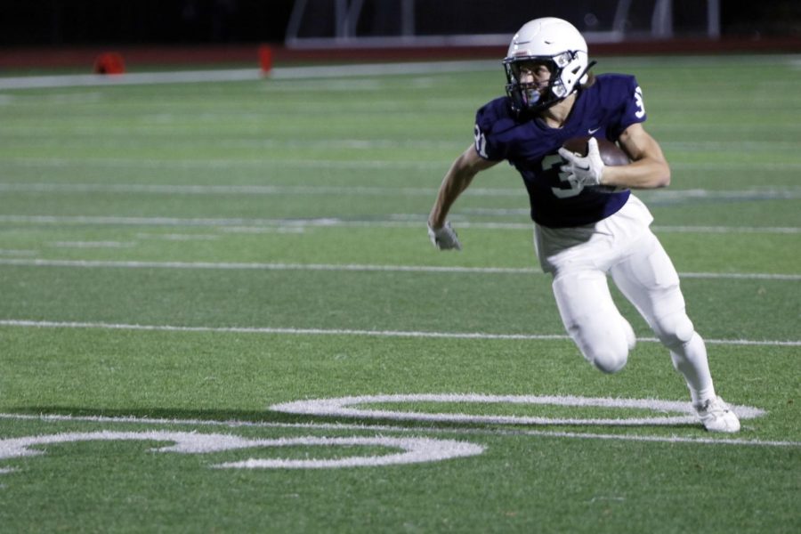 Running towards the endzone, sophomore Andrew Watts assesses the defense. 