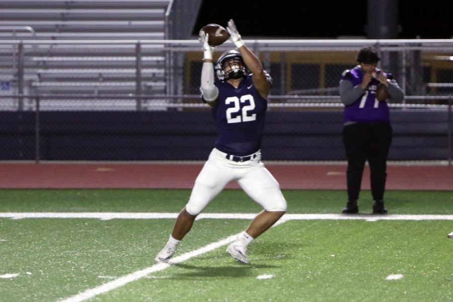 Reaching for a pass, junior Evan Seifert looks over his shoulder to complete the reception. 