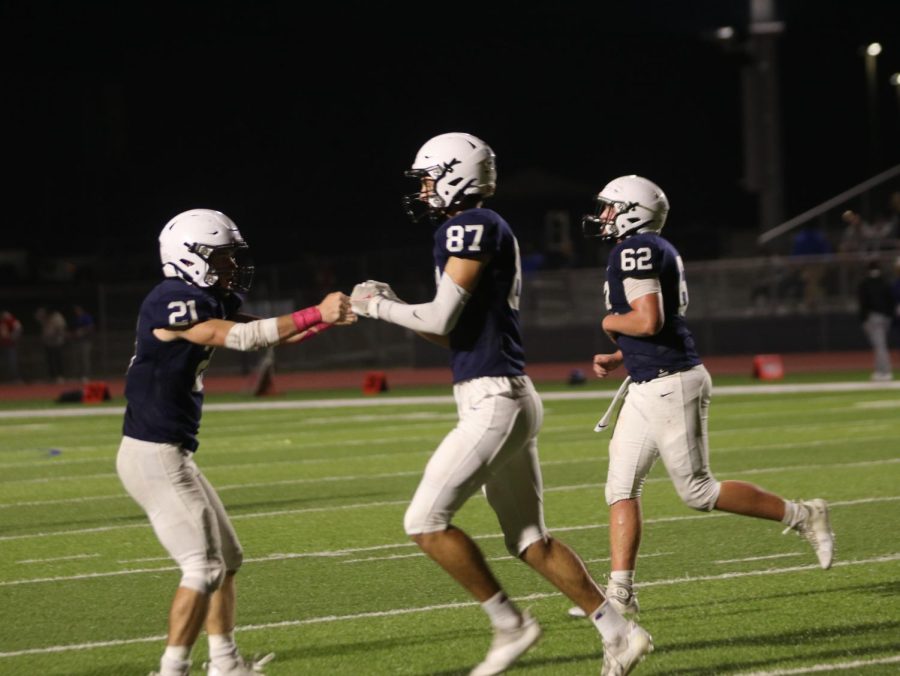 Fist bumping his teammate, senior Will Smoots and junior Tristan Baker celebrate as they run off the field.
