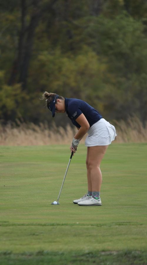 Finishing the first hole, junior Kathryn Yockey focuses on her put.