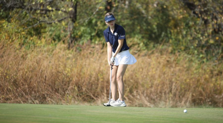 After hitting the ball, senior Paige Dinslage watches her ball roll into the hole.