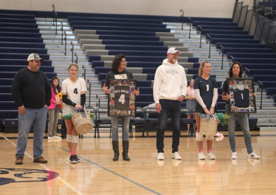 Seniors Sidney Kacsir and Madeline Schnepf stand proudly by their parents as they are recognized on senior night.
