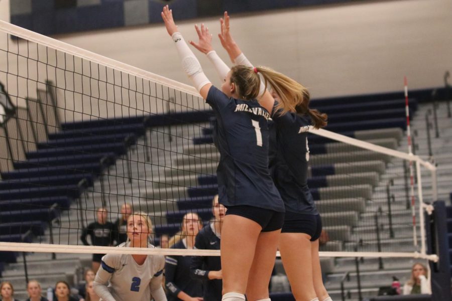 Working together, senior Madeline Schnepf and sophomore Saida Jacobs time their block against their opponents.