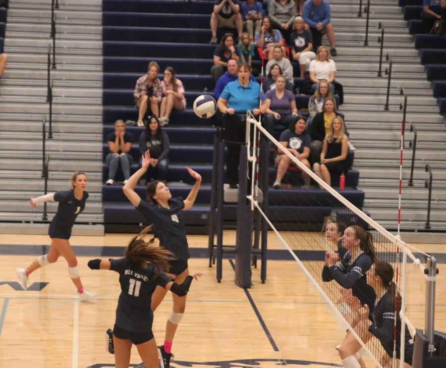 Reaching with her arms up, sophomore Ashlyn Blazer makes the kill against Olathe West. 
