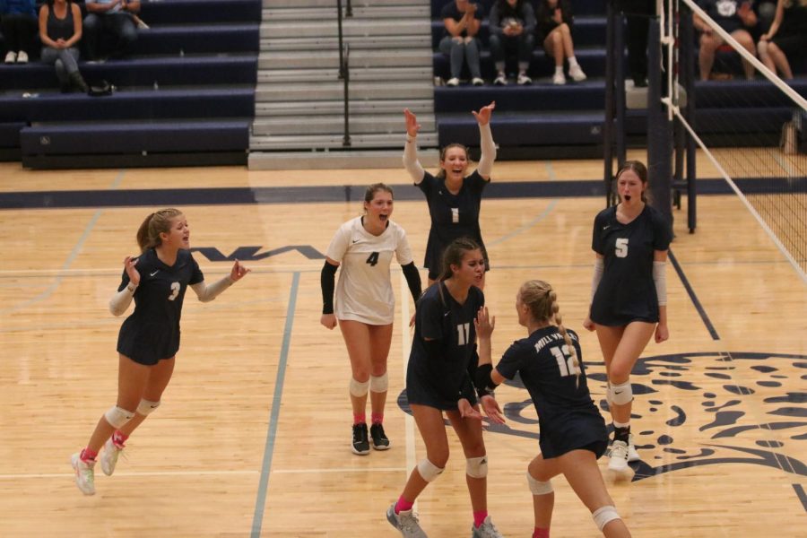 After the kill, junior Addison Bailey high fives freshman Ella Florez as they celebrate with the rest of the team. 
